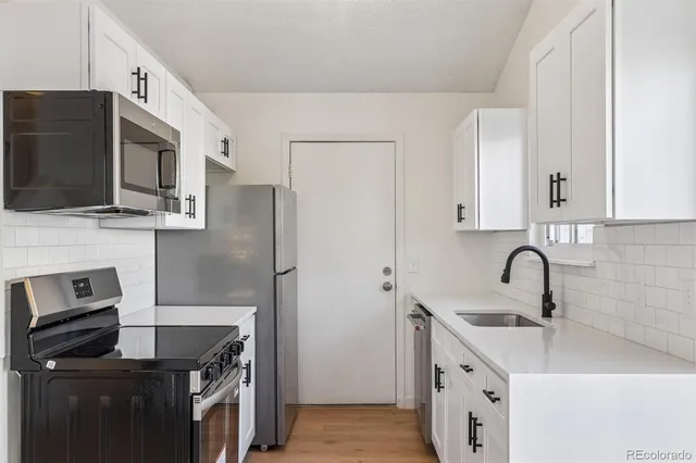 a kitchen with stainless steel appliances a stove microwave and sink