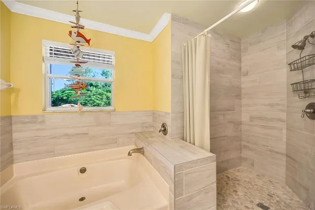 a bathroom with a tub a sink and a window