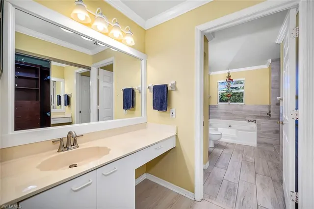 a en suite bathroom with a tub sink and mirror