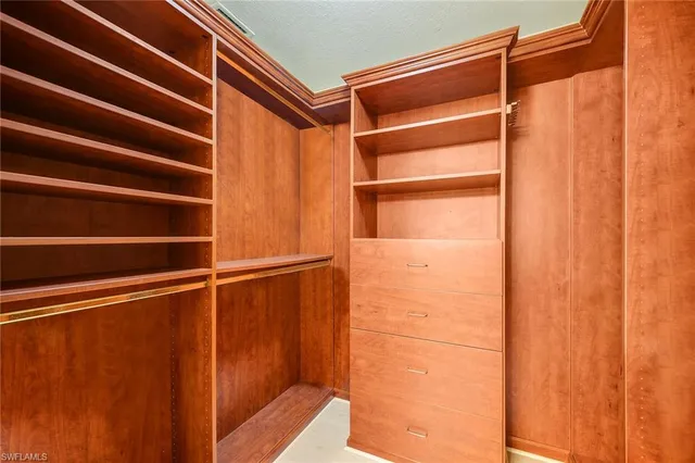 a view of walk in closet with empty racks