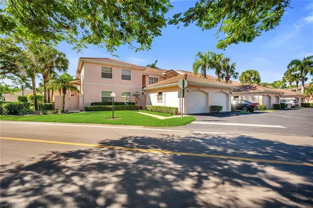 a view of a house with a yard and large trees