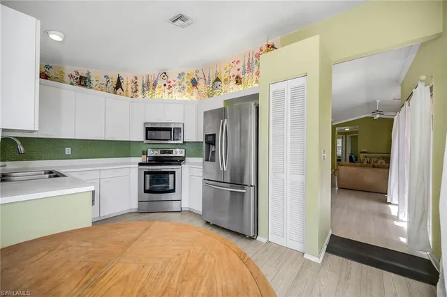 a kitchen with a refrigerator and a stove top oven