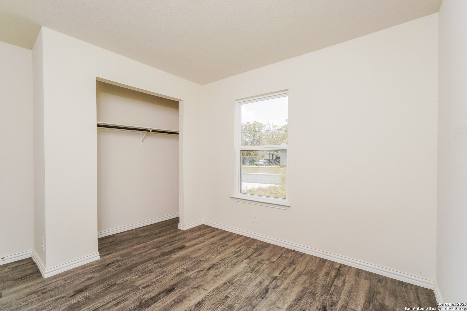527 Elley Street Seguin, TX 78155 - Photo 18 of 21 a view of an empty room with wooden floor and a window