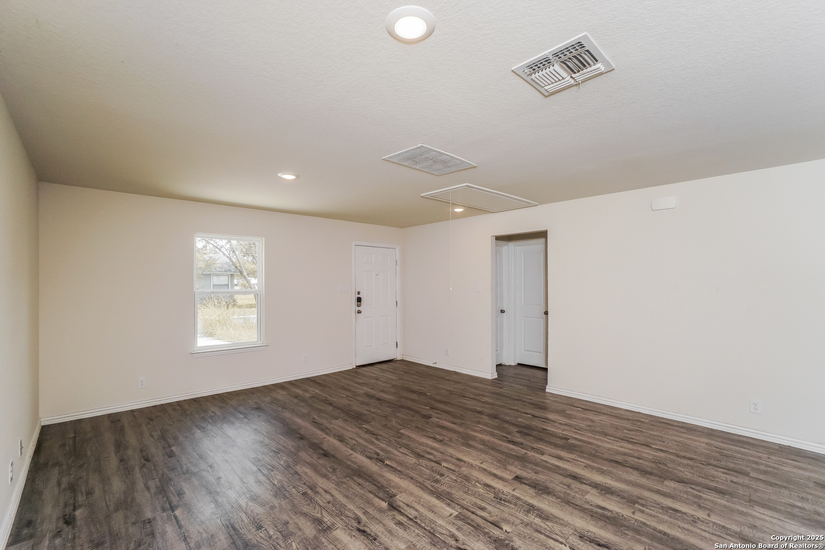 527 Elley Street Seguin, TX 78155 - Photo 5 of 21 an empty room with wooden floor and windows