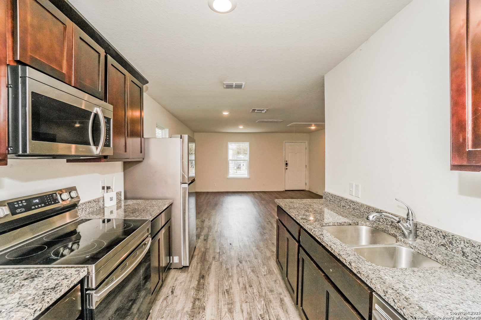 527 Elley Street Seguin, TX 78155 - Photo 8 of 21 a kitchen with stainless steel appliances granite countertop a sink a stove and a wooden floors