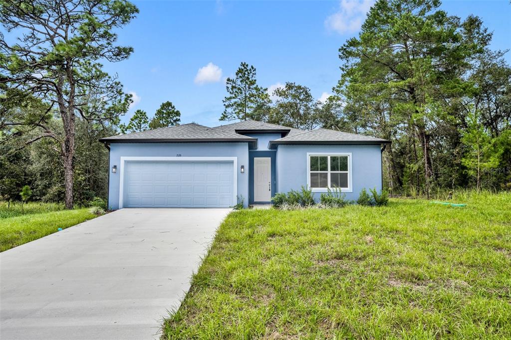 7126 North Ripley Drive Citrus Springs, FL 34433 - Photo 1 of 1 a front view of a house with a yard and garage