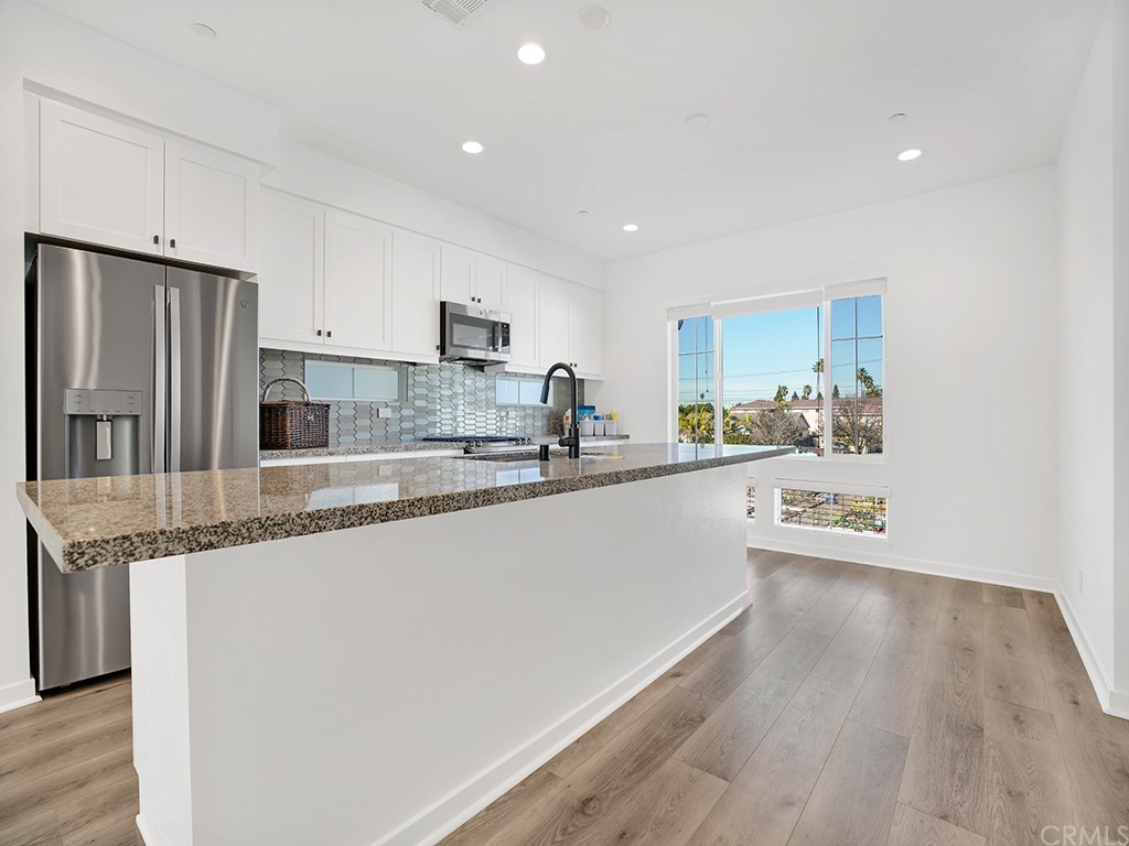 524 Caleigh Lane Costa Mesa, CA 92627 - Photo 4 of 19 a large kitchen with stainless steel appliances granite countertop a stove a sink and a refrigerator