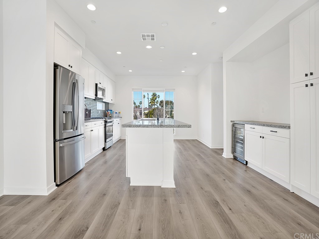 524 Caleigh Lane Costa Mesa, CA 92627 - Photo 5 of 19 a kitchen with white cabinets and stainless steel appliances