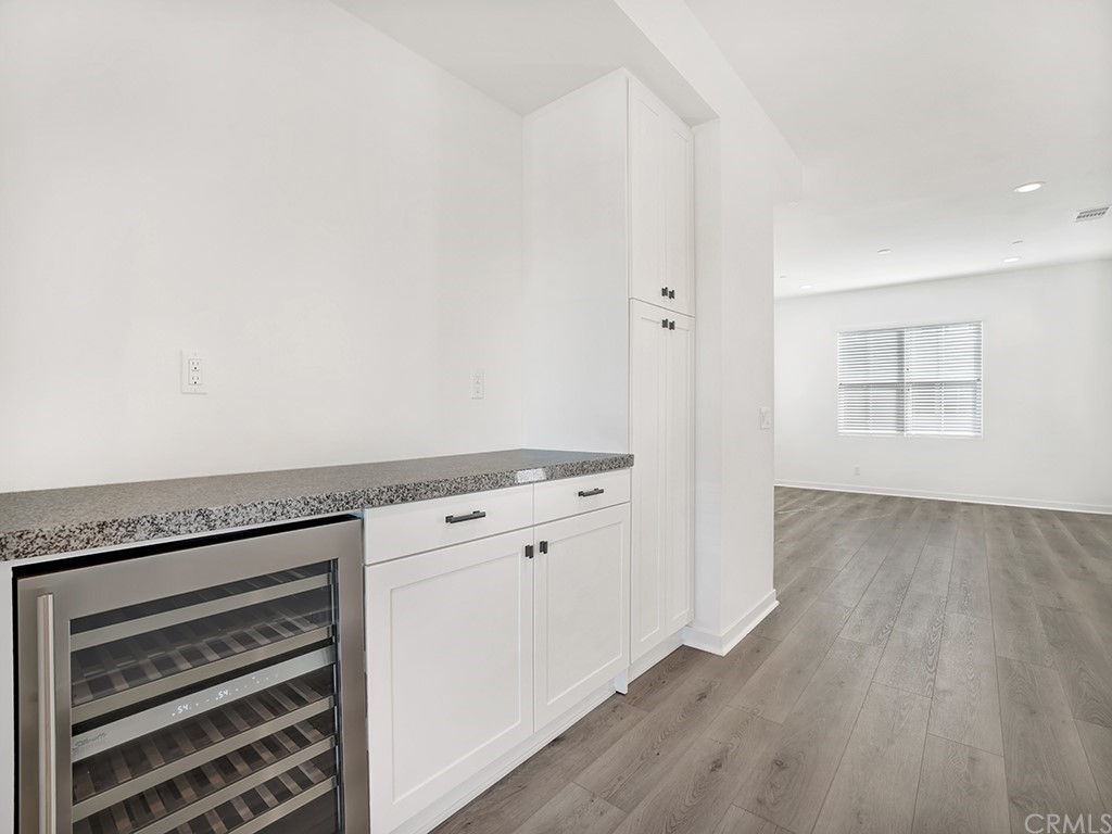 524 Caleigh Lane Costa Mesa, CA 92627 - Photo 7 of 19 an empty room with wooden floor and cabinet