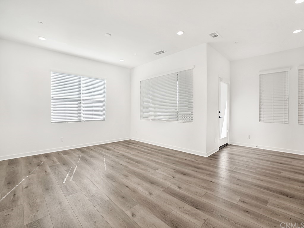 524 Caleigh Lane Costa Mesa, CA 92627 - Photo 8 of 19 an empty room with wooden floor and windows