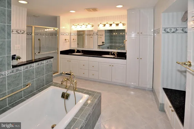a bathroom with a tub sink and mirror