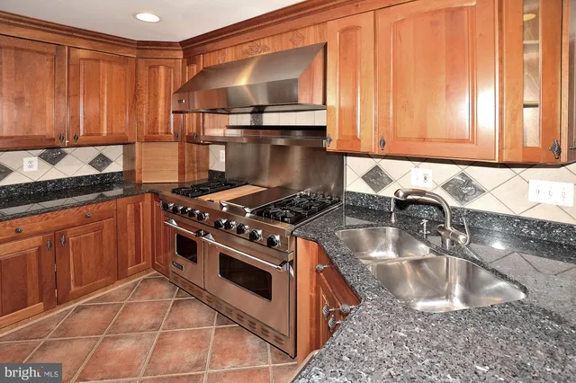 a kitchen with granite countertop a sink stainless steel appliances and cabinets