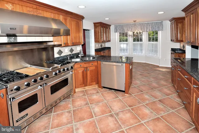 a kitchen with stainless steel appliances a stove a sink and a microwave