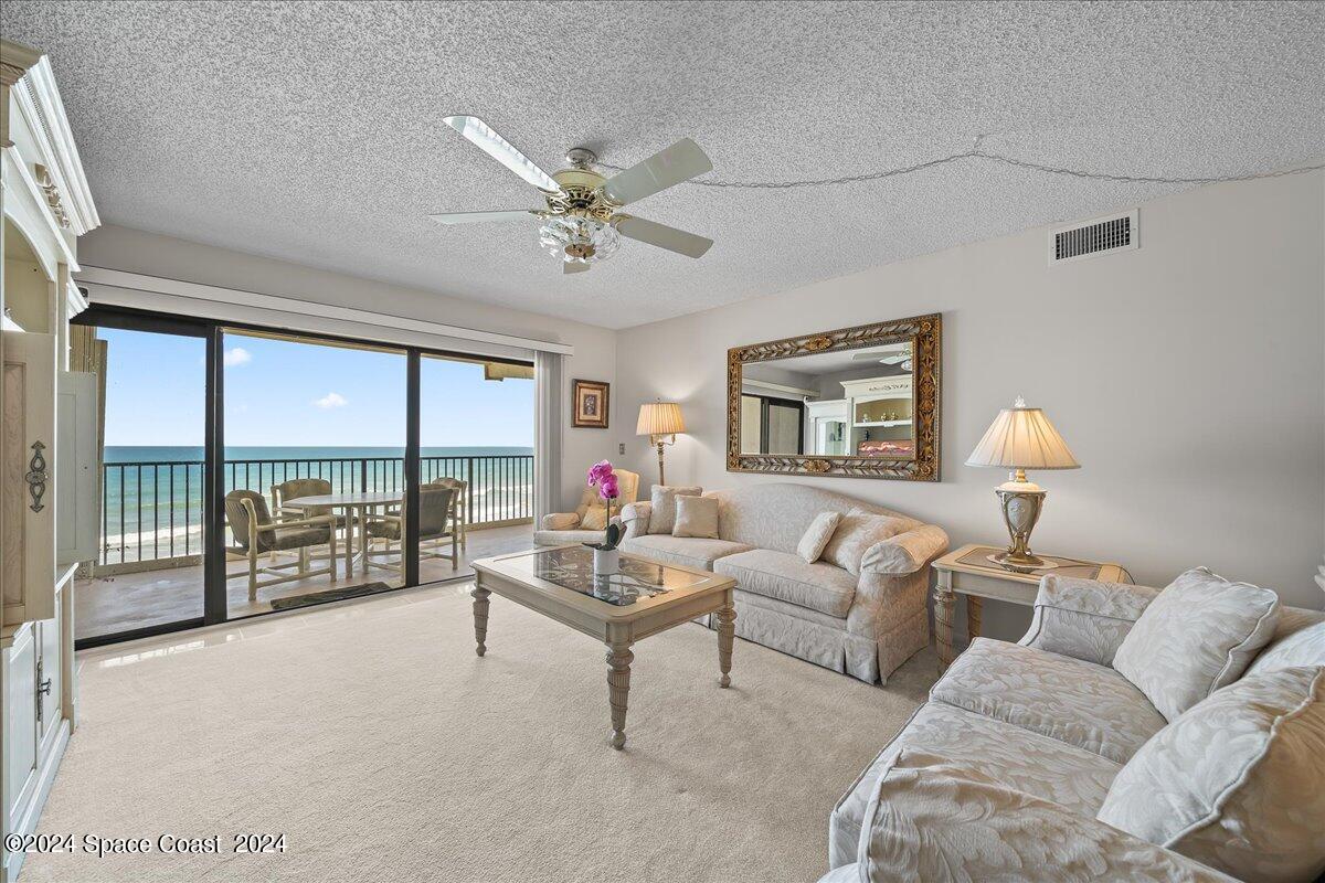2725 North Hwy A1A, Unit 403 Indialantic, FL 32903 - Photo 11 of 37 a living room with furniture and a large window with balcony view