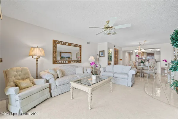 a living room with furniture a chandelier and a window
