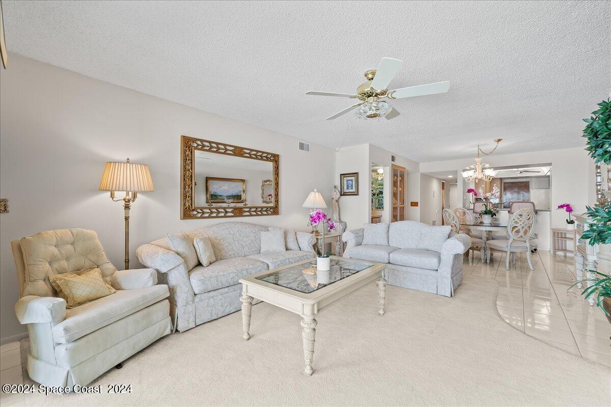2725 North Hwy A1A, Unit 403 Indialantic, FL 32903 - Photo 12 of 37 a living room with furniture a chandelier and a window