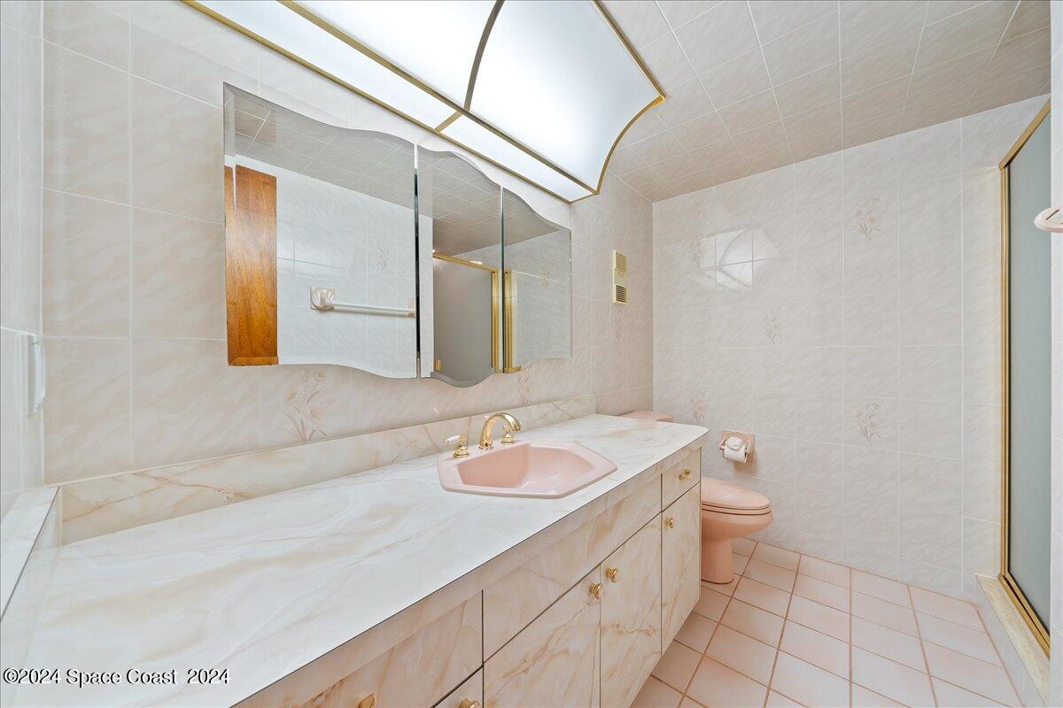 2725 North Hwy A1A, Unit 403 Indialantic, FL 32903 - Photo 16 of 37 a bathroom with a sink a toilet and mirror