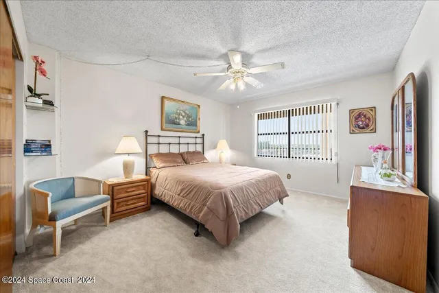 a spacious bedroom with a bed dresser and a flat screen tv