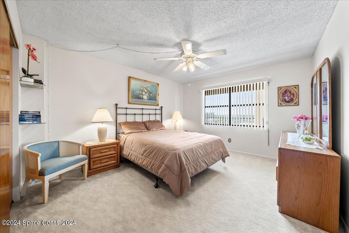 2725 North Hwy A1A, Unit 403 Indialantic, FL 32903 - Photo 18 of 37 a spacious bedroom with a bed dresser and a flat screen tv