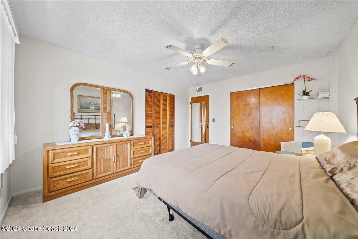 2725 North Hwy A1A, Unit 403 Indialantic, FL 32903 - Photo 19 of 37 a spacious bedroom with a large bed and a chandelier