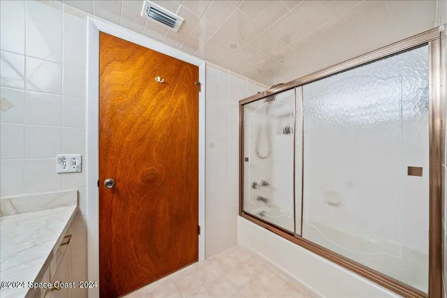 a bathroom with a granite countertop shower and a sink