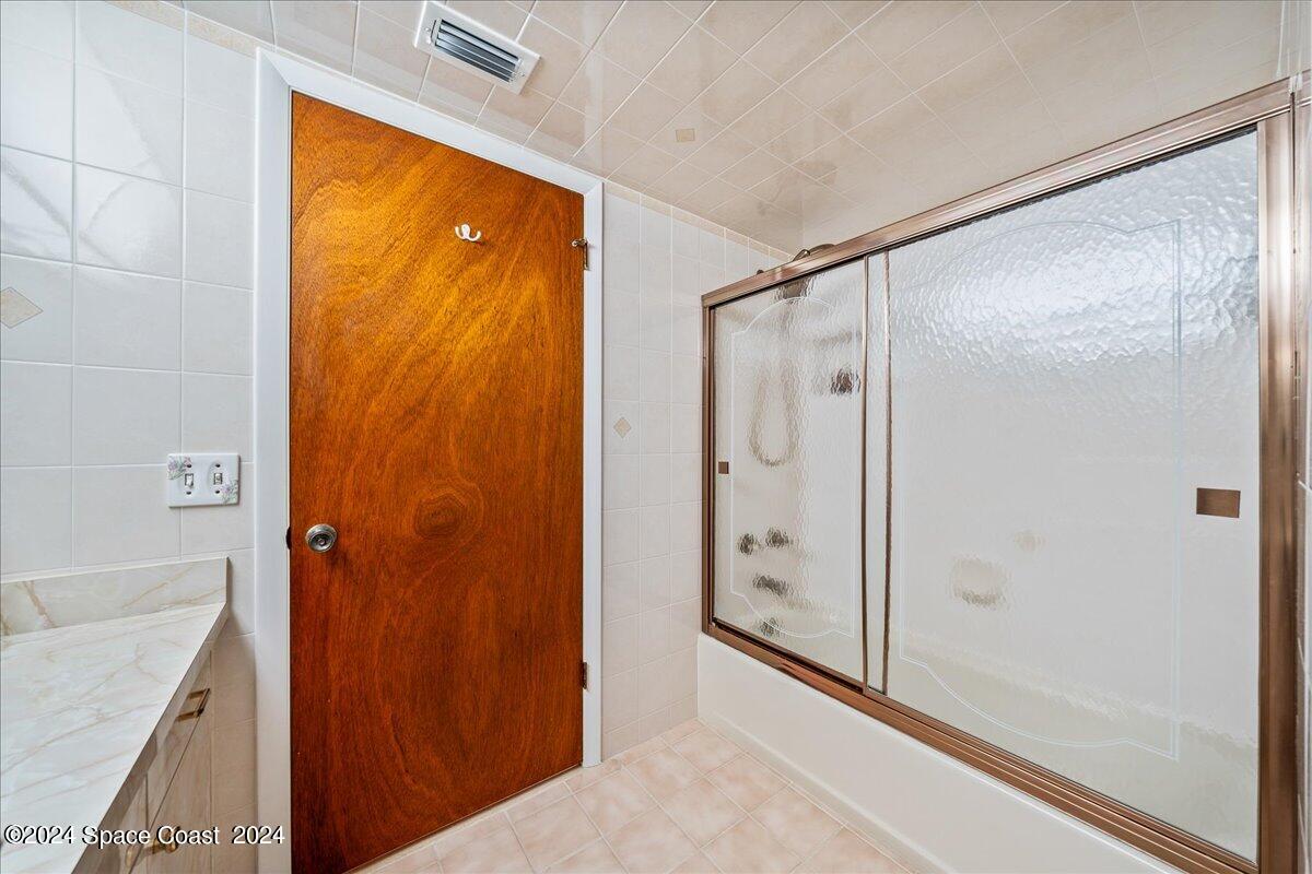 2725 North Hwy A1A, Unit 403 Indialantic, FL 32903 - Photo 21 of 37 a bathroom with a granite countertop shower and a sink