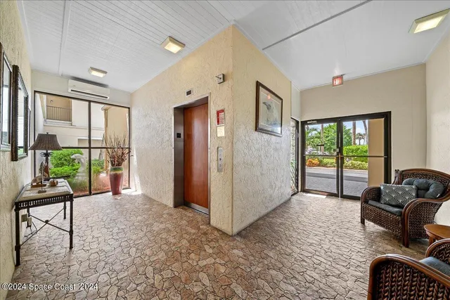 a view of a livingroom with furniture and floor to ceiling window