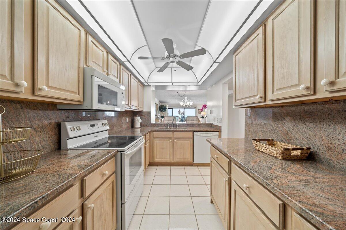 2725 North Hwy A1A, Unit 403 Indialantic, FL 32903 - Photo 7 of 37 a kitchen with stainless steel appliances granite countertop a sink a stove and cabinets