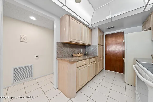 a kitchen with granite countertop white cabinets and stainless steel appliances