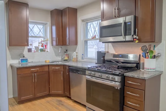 a kitchen with stainless steel appliances a stove microwave and sink