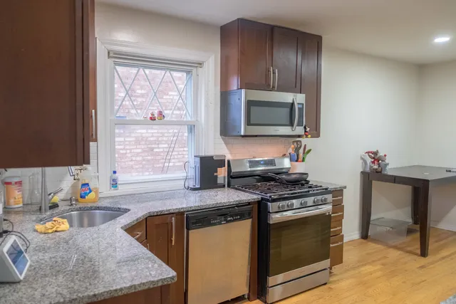 a kitchen with stainless steel appliances granite countertop a sink stove and microwave