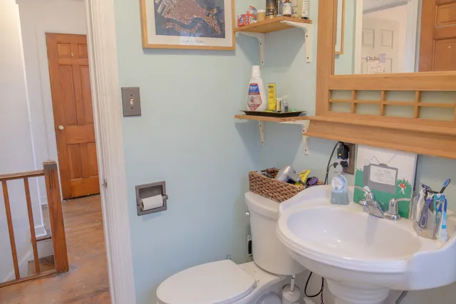 a bathroom with a toilet sink and mirror