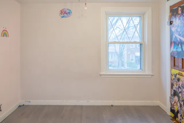 en empty room with window and wooden floor