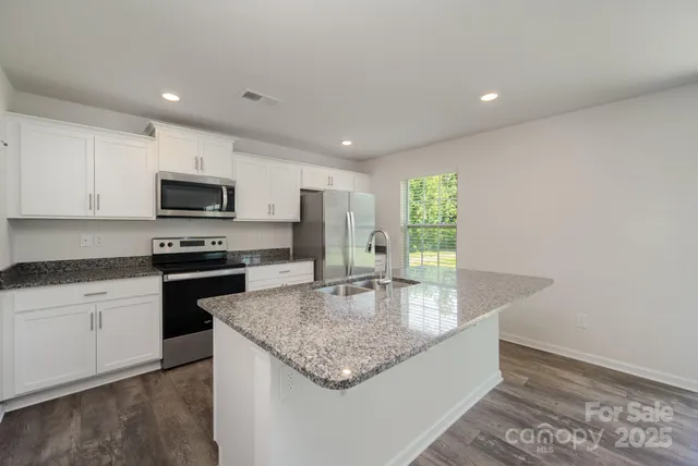 a kitchen with sink a microwave and cabinets