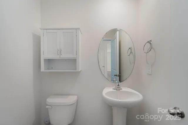 a bathroom with a toilet a sink and mirror