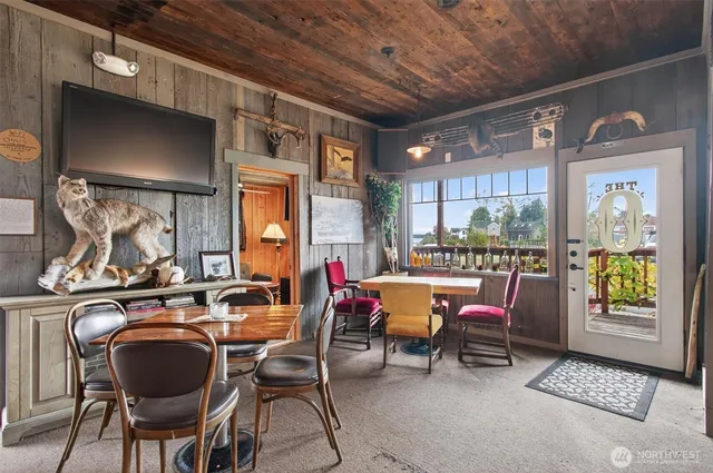 a dining room with furniture a flat screen tv and a floor to ceiling window
