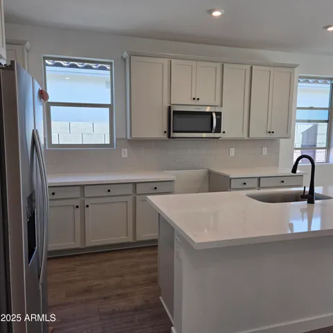 a kitchen with white cabinets and a sink