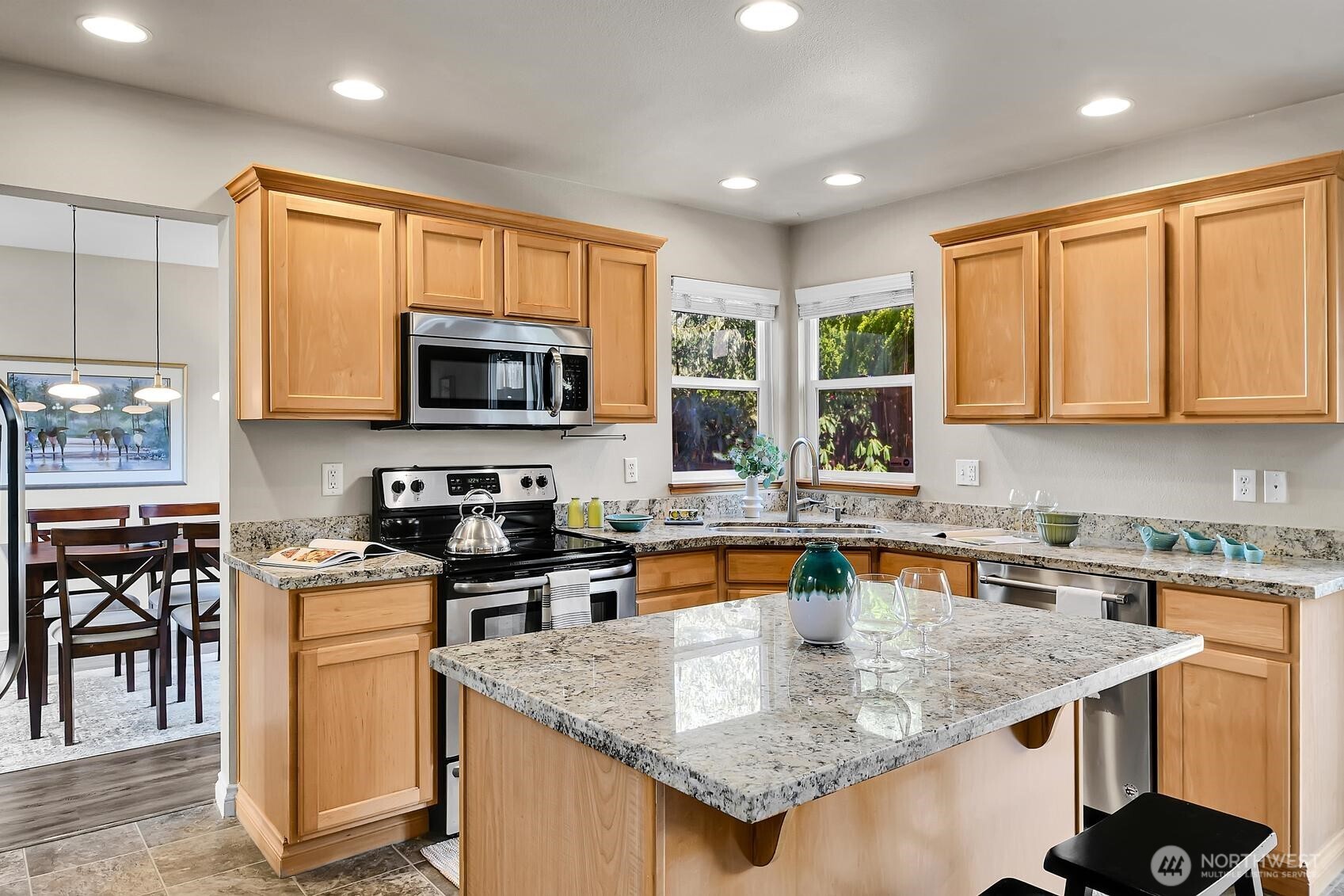18524 114th Avenue Southeast Renton, WA 98055 - Photo 7 of 20 a kitchen with stainless steel appliances granite countertop a stove top oven a sink a microwave and a refrigerator