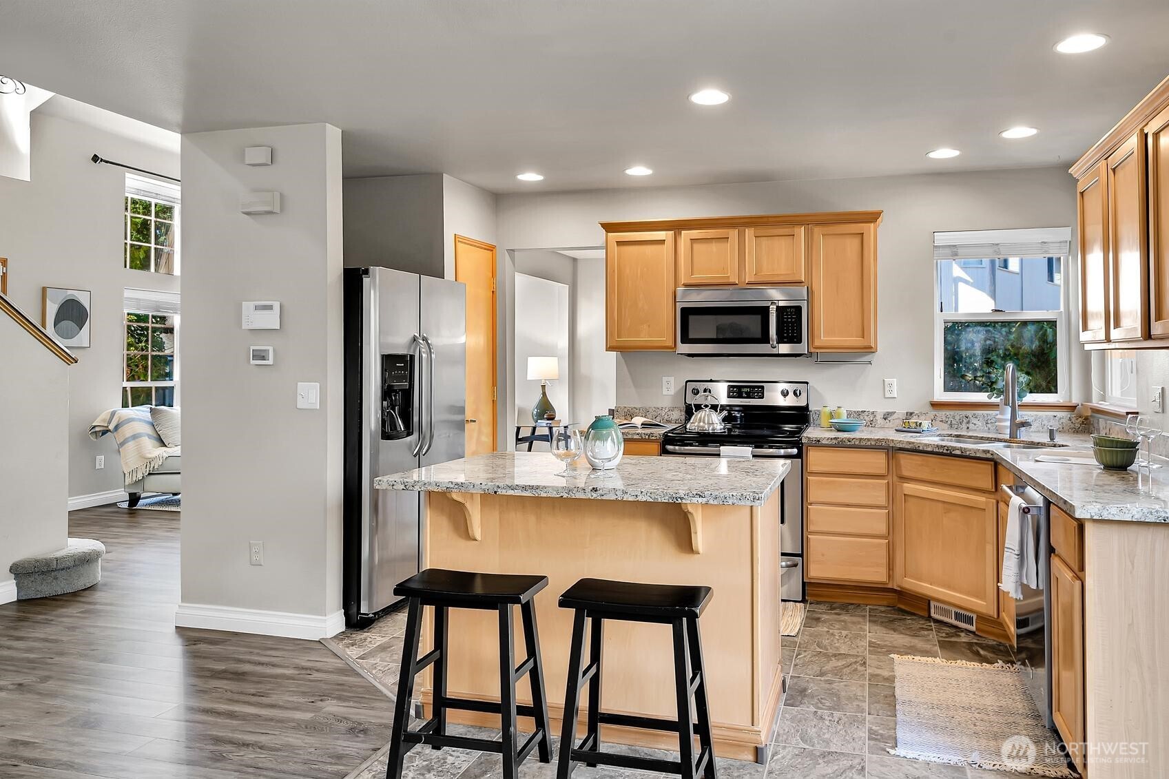 18524 114th Avenue Southeast Renton, WA 98055 - Photo 8 of 20 a kitchen with stainless steel appliances granite countertop a refrigerator a stove top oven a sink dishwasher and white cabinets with wooden floor