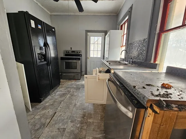 a kitchen with granite countertop a refrigerator stove and sink
