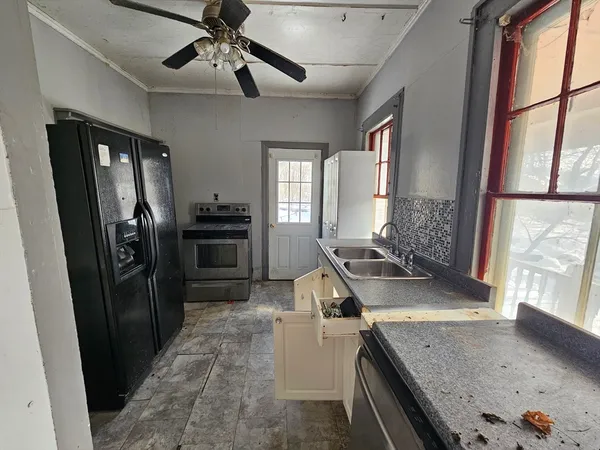 a kitchen with stainless steel appliances granite countertop a sink a stove and a refrigerator