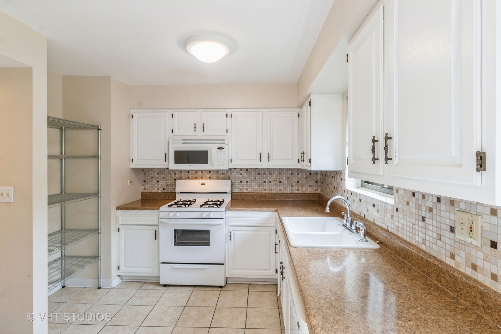 348 East Rimini Court, Unit 348 Palatine, IL 60067 - Photo 4 of 10 a kitchen with a stove sink and cabinets