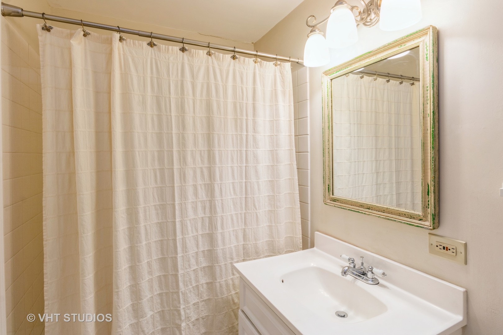 348 East Rimini Court, Unit 348 Palatine, IL 60067 - Photo 9 of 10 a bathroom with a sink a mirror and a shower curtain