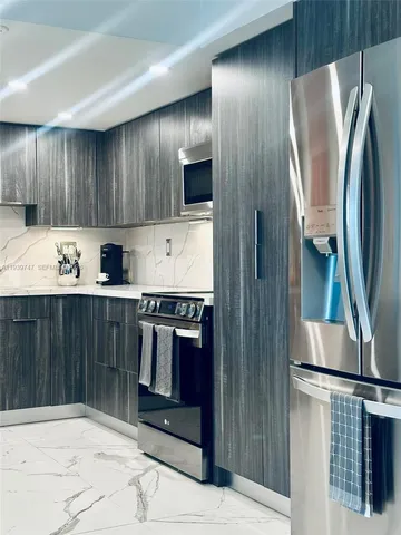 a kitchen with stainless steel appliances a refrigerator and a stove top oven