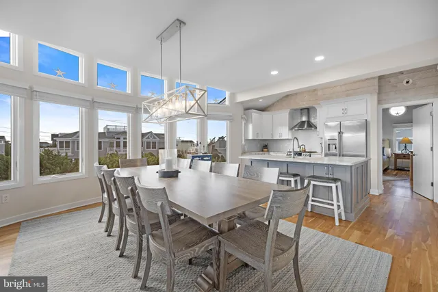 a view of a dining room and livingroom with furniture wooden floor a chandelier