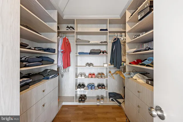 a view of walk in closet with clothes and shoes