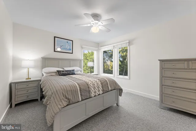 a spacious bedroom with a bed a dresser and a window