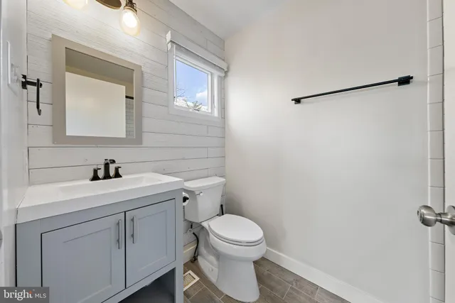 a bathroom with a toilet a sink and mirror