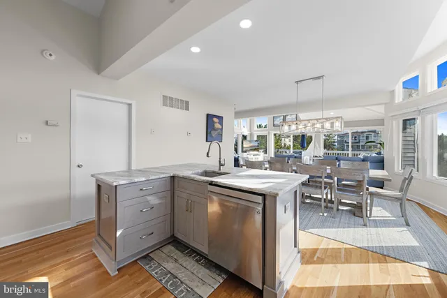 a kitchen with stainless steel appliances granite countertop a stove and a view of living room