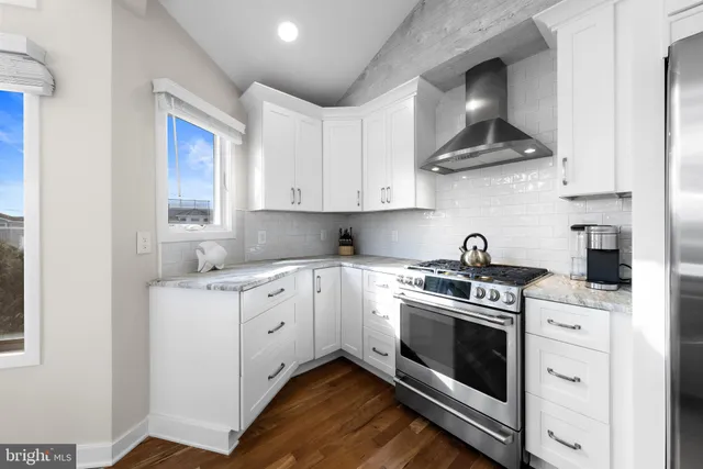a kitchen with stainless steel appliances granite countertop a stove sink and cabinets